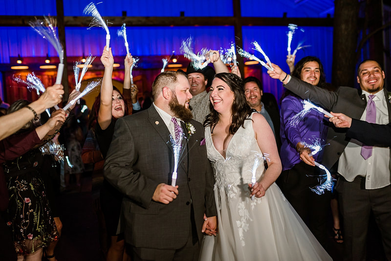 bride and groom surrounded my wedding guests at their wedding reception send off at Avon Acres