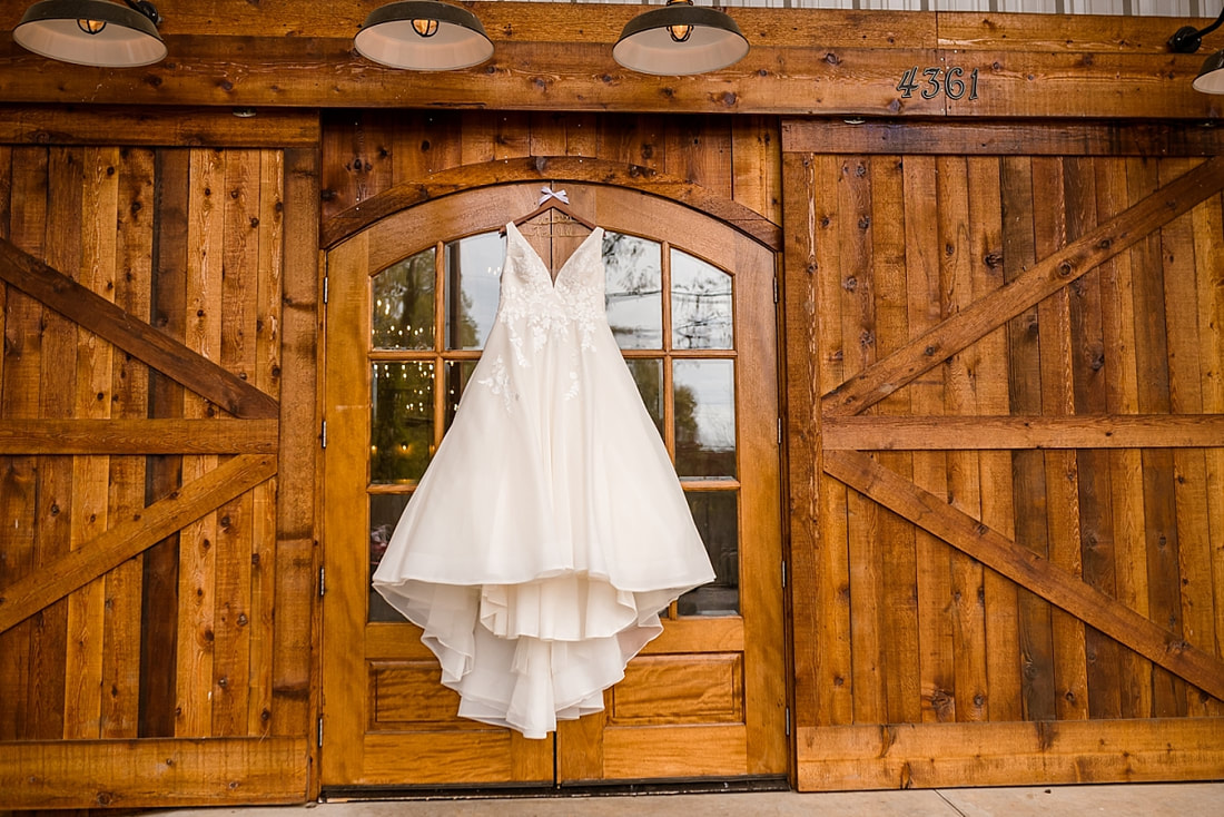 Maggie Louise wedding gown hanging on barn door at Avon Acres in Memphis, TN