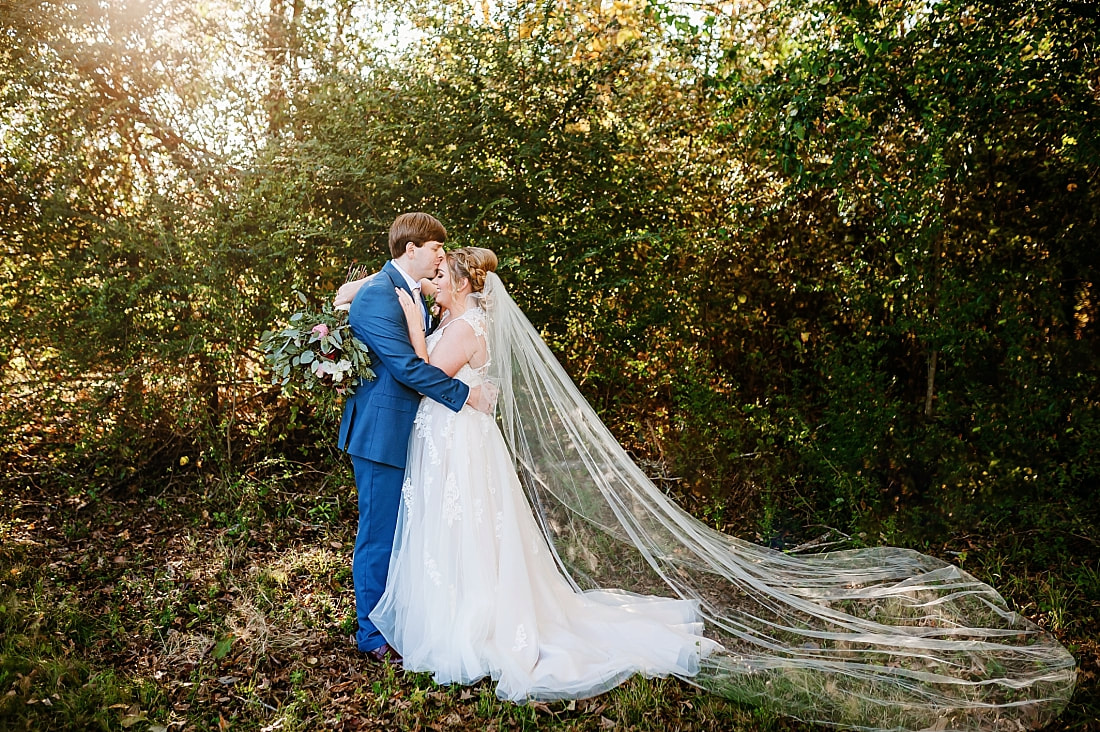 Groom kissing bride on the forehead at Cypress Hall in Hernando, MS