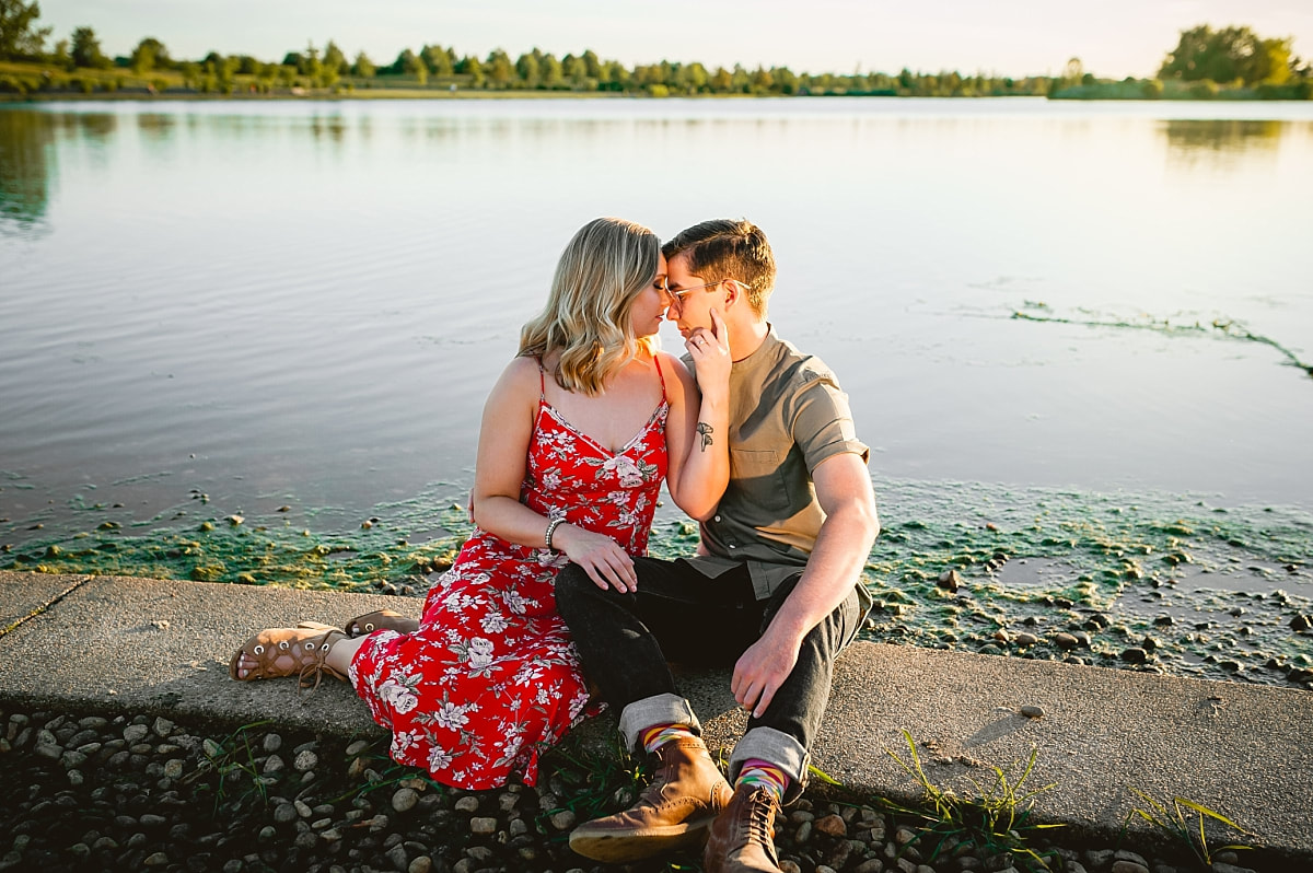 couple posing for engagement photos by the lake at shelby farms park in memphis, tn