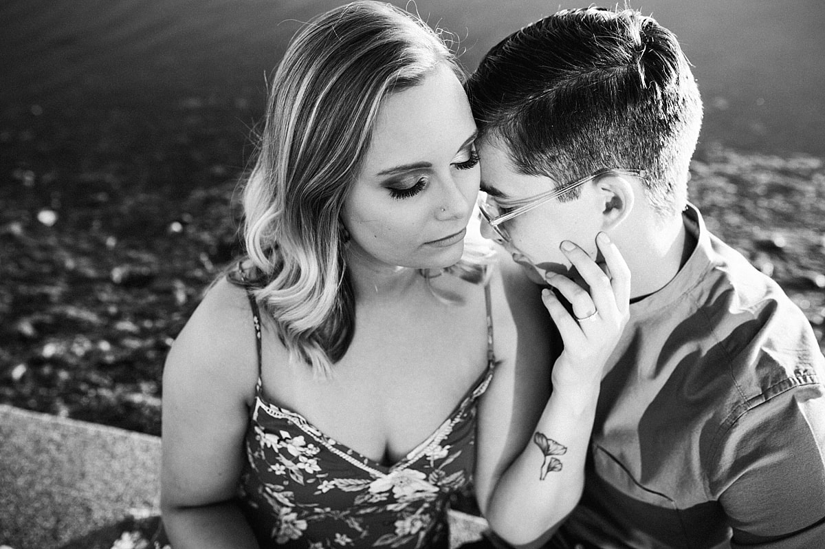 couple posing for engagement photos by the lake at shelby farms park in memphis, tn