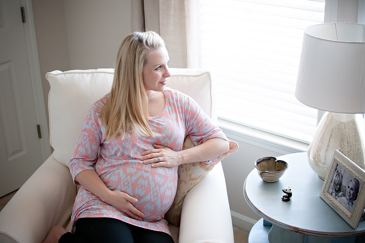 pregnant mother sitting in the rocking chair in her downtown Memphis nursery