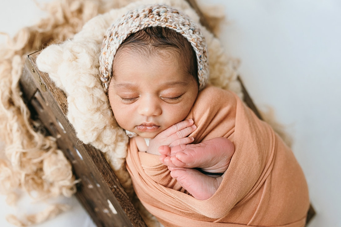 sweet newborn swaddled in sunset orange for newborn photos memphis