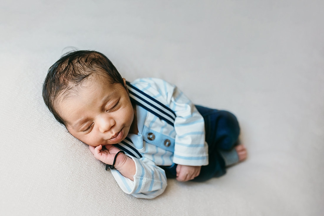 newborn baby boy wearing blue suspenders for newborn photos in memphis