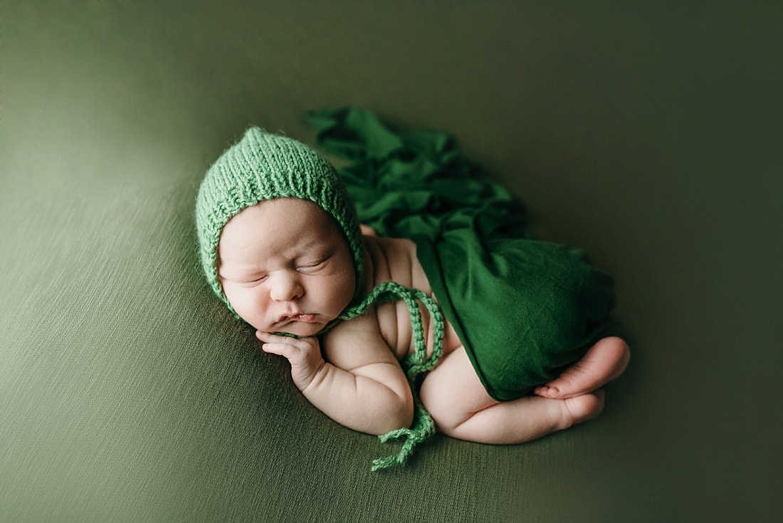 newborn baby boy posed and sleeping on green blanket in Memphis, TN