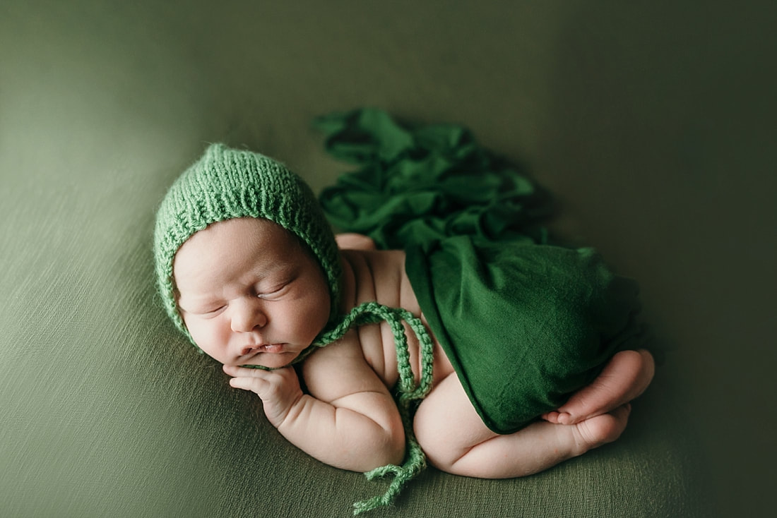 newborn baby boy posed and sleeping on green blanket in Memphis, TN