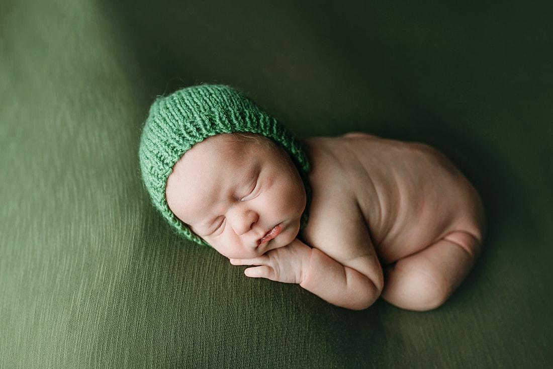 newborn baby boy posed and sleeping on green blanket in Memphis, TN