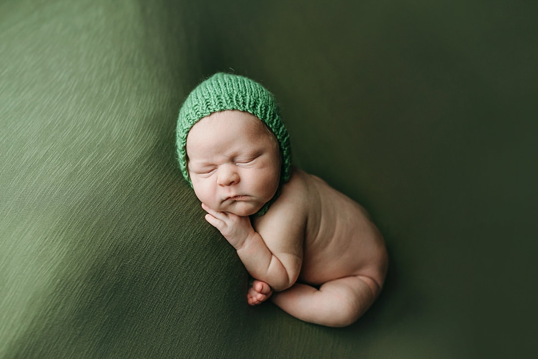 newborn baby boy posed and sleeping on green blanket in Memphis, TN