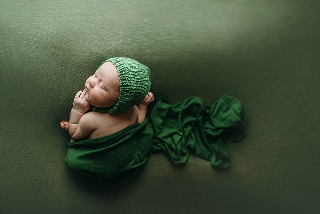 newborn baby boy posed and sleeping on green blanket in Memphis, TN