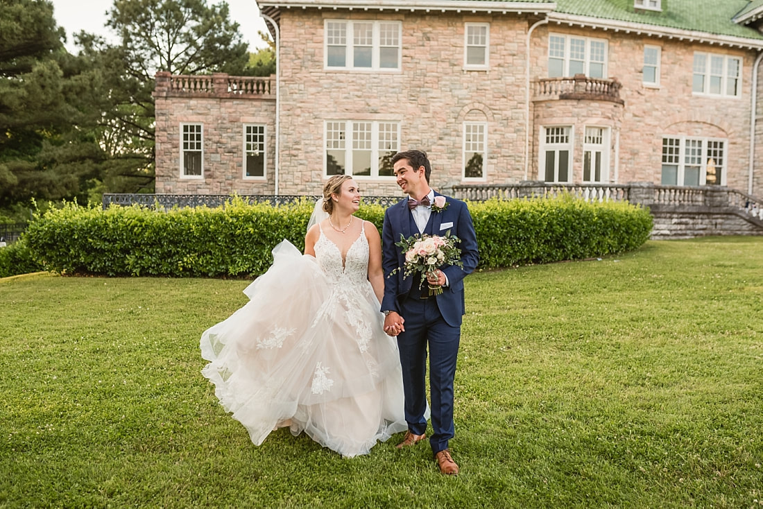 bride and groom walking holding hands in front of the Pink Palace + Pink Palace Wedding + Memphis, TN